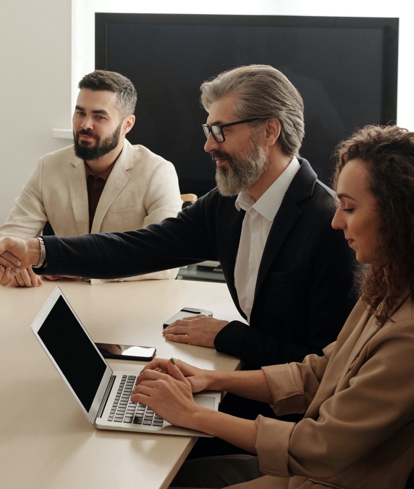 Three colleagues meeting around a laptop